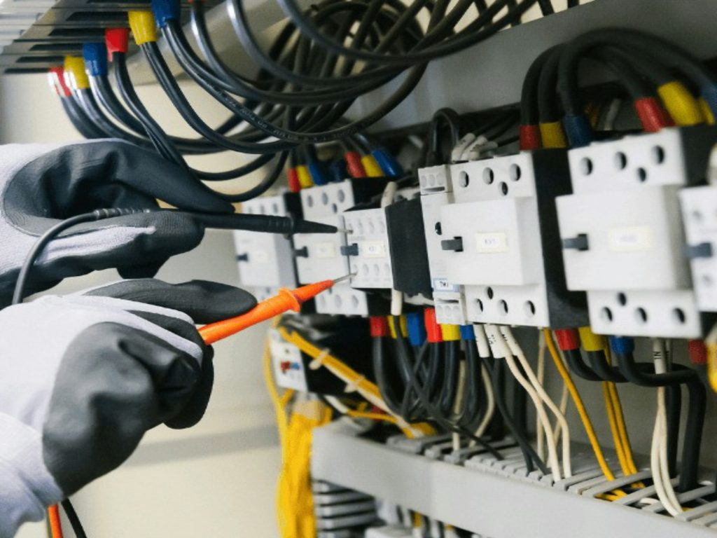 Técnico a medir um quadro elétrico